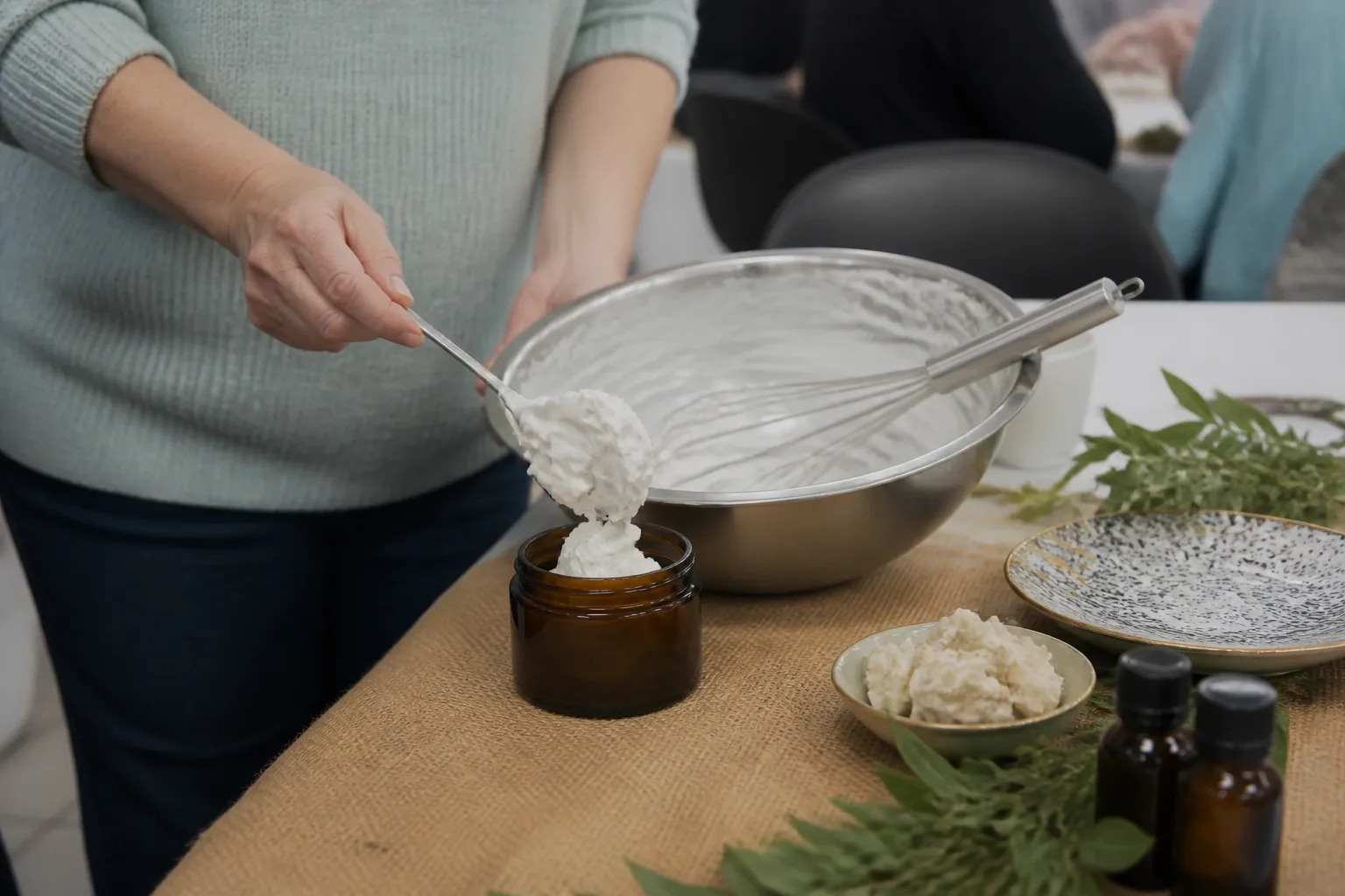 Whipped body butter in an open jar beside its ingredients