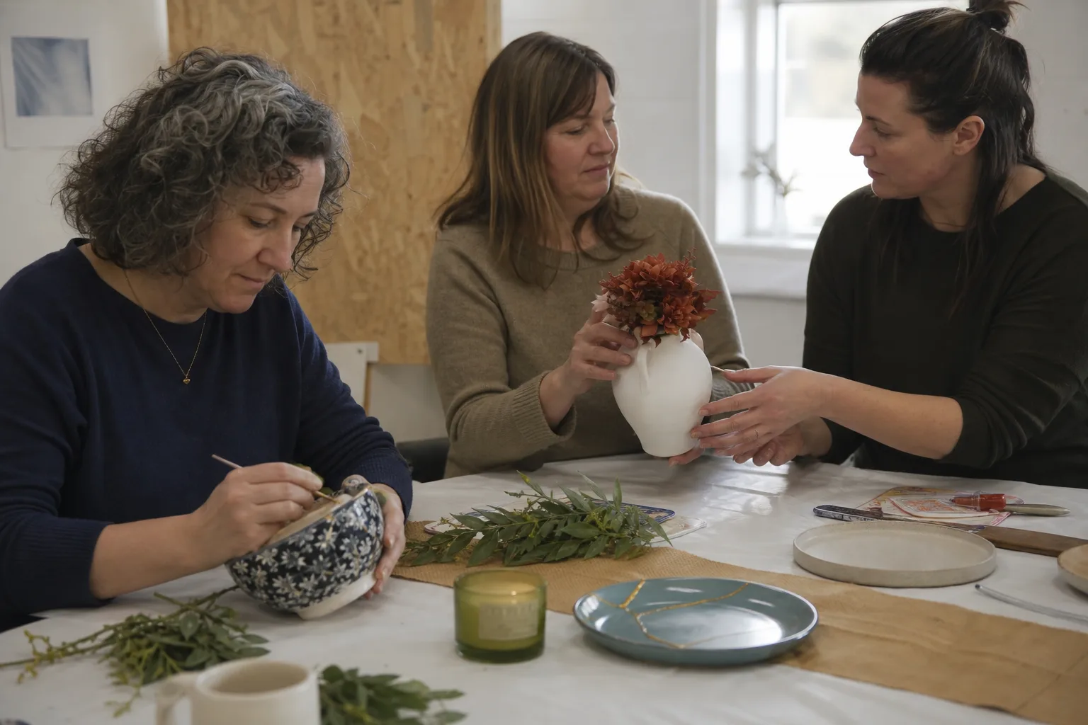 Colleagues around a workshop table, comparing what they have made
