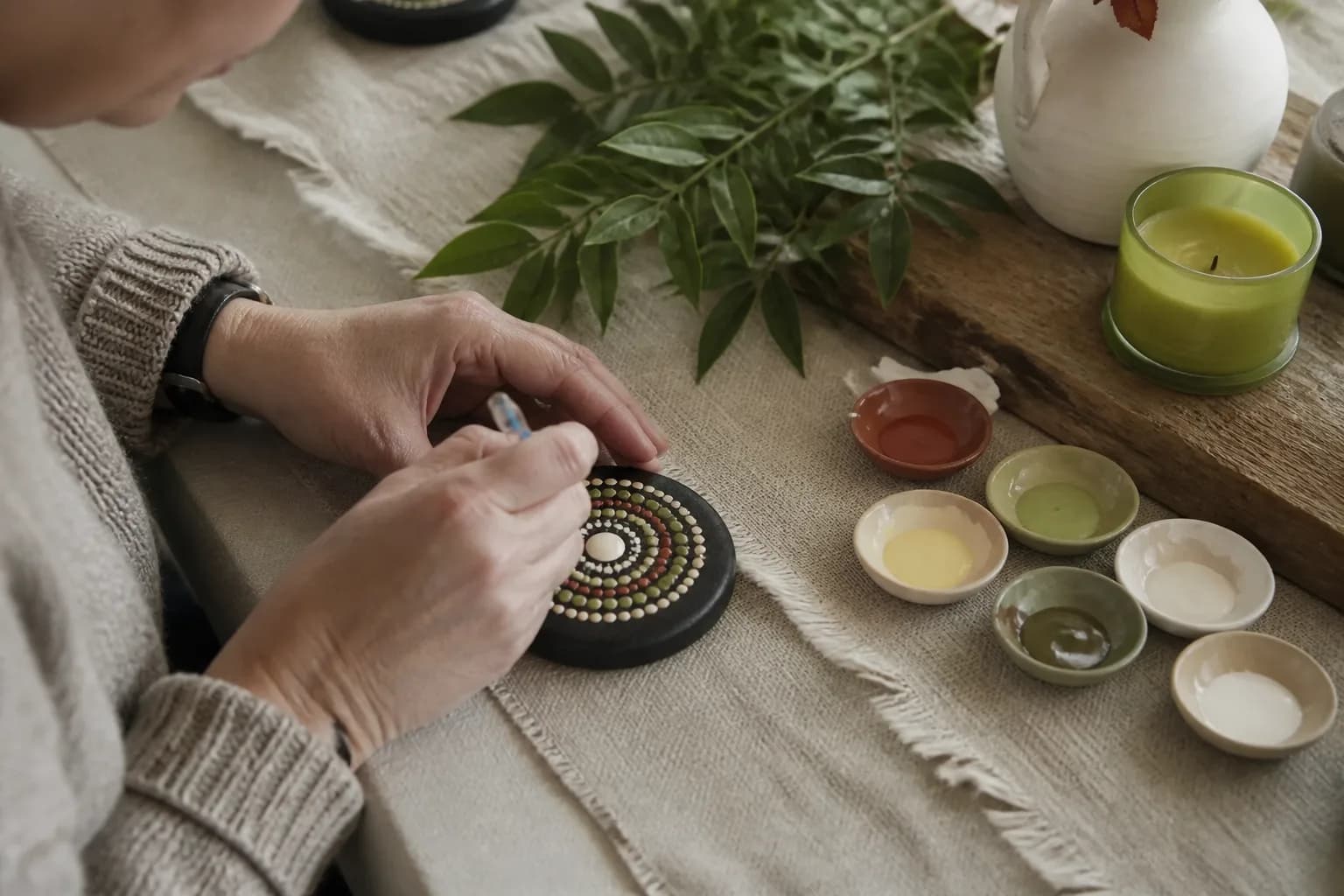 A mandala being built in dots on a dark round surface